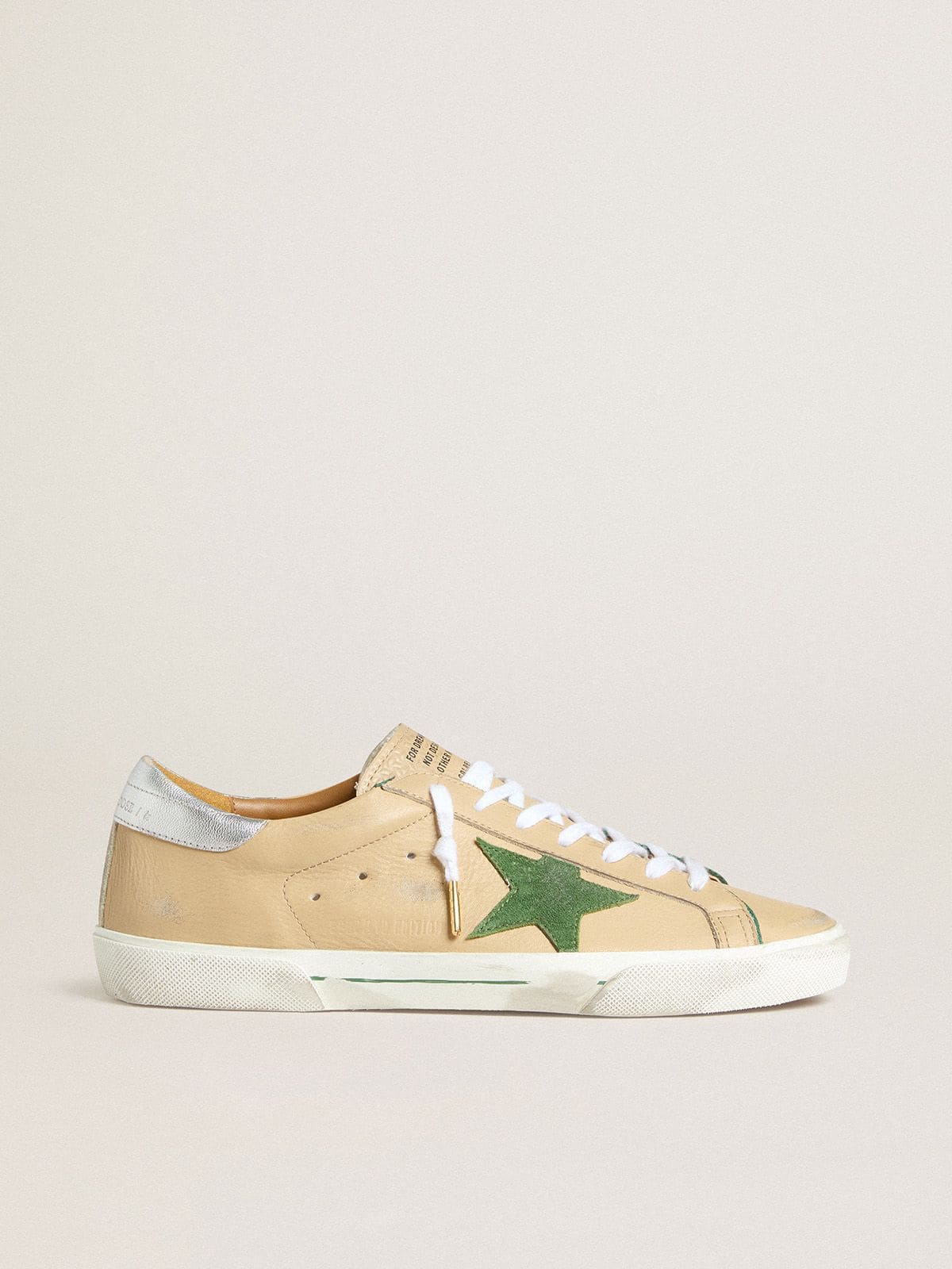 215288297b7a942c694a39ae158e76942ecc8648c7845d996a408c0fb690a5de Super-Star LTD in beige leather with green suede star and silver foiled leather heel tab - Image 1