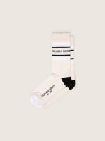 Blush-colored socks with distressed details and black and white stripes