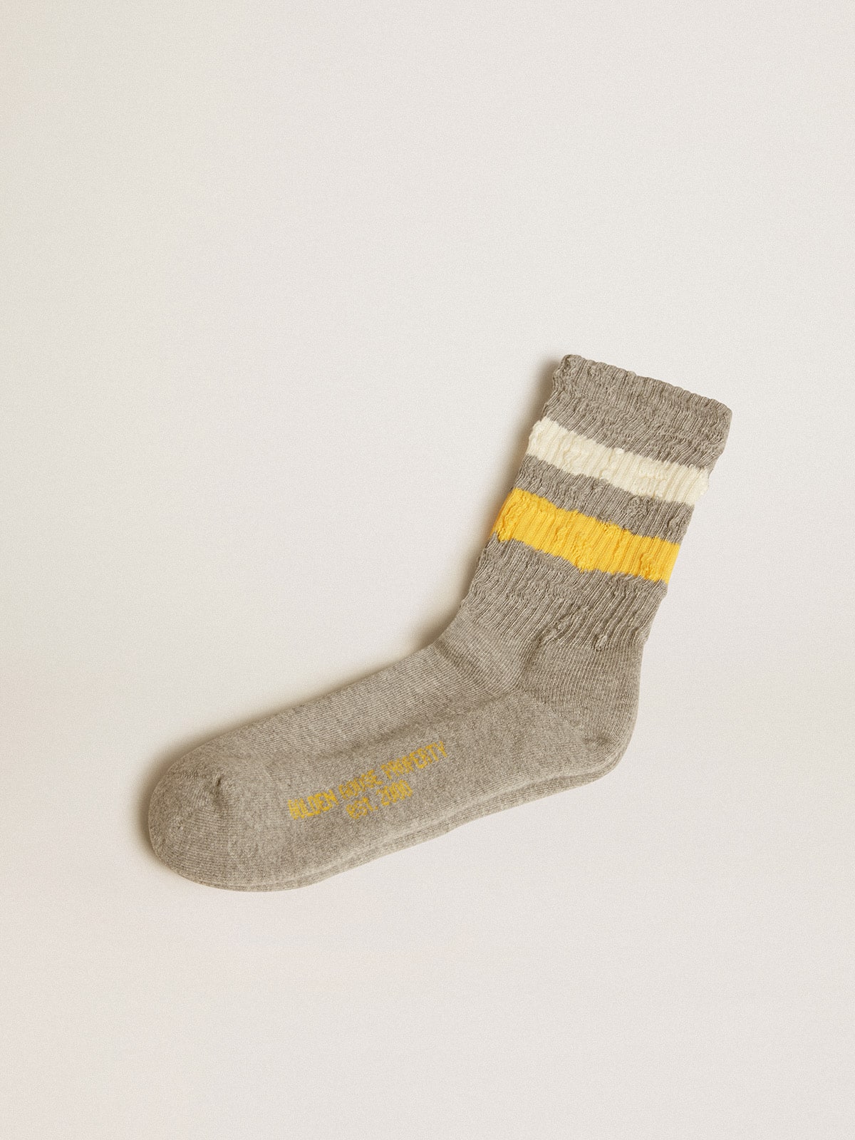 90c04cac9d6e3d8a45fc27c5478055b1f2585612737e3b27b0bdc4d0a58f7c48 Gray socks with distressed details and yellow and white stripes - Image 1